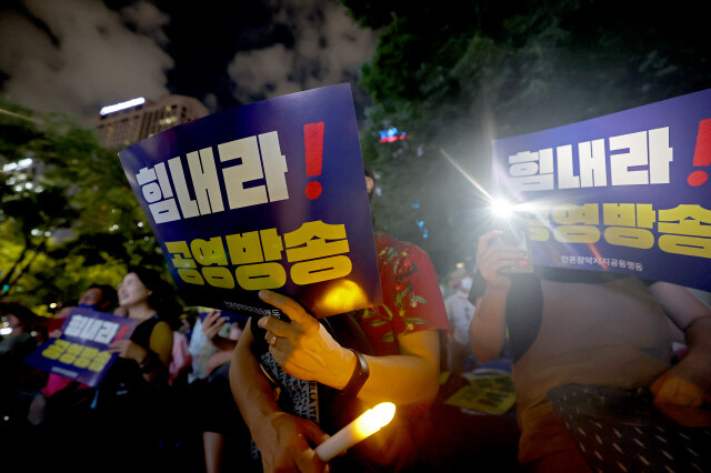 '힘내라 공영방송, 지키자 MBC' 시민문화제가 2024년 8월21일 저녁 서울 광화문 동화면세점 앞에서 열려 참석자들이 손팻말을 들고 구호를 외치고 있다. 이종근 선임기자 root2@hani.co.kr