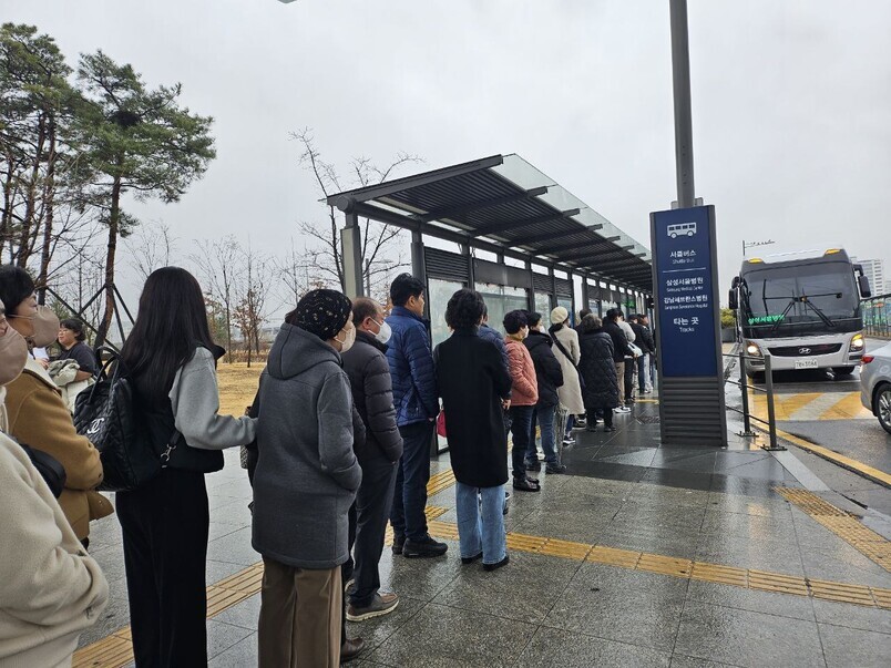 People wait for a shuttle bus to Samsung Medical Center at Suseo Station in Seoul on Feb. 19. (Yoon Yeon-jeong/The Hankyoreh)