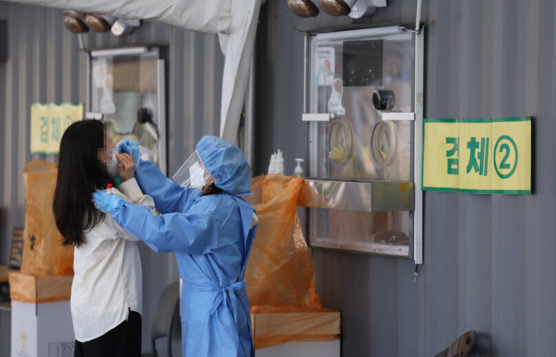 A person receives a PCR COVID-19 test at a temporary screening station in Seoul Plaza on April 11. (Yonhap News)