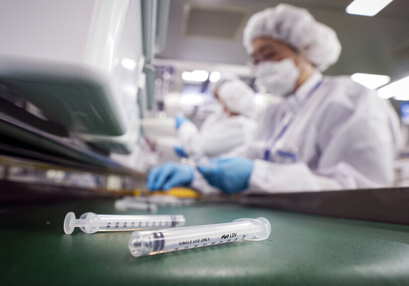 Employees at PoongLim Pharmatech in Gunsan, North Jeolla Province, produce low dead space (LDS) syringes on Feb. 18. (Yonhap News)