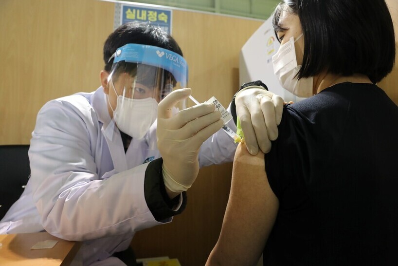 A medical worker in Cheonan’s Dongnam District administers a vaccine to a staff member at a medical facility on March 3, 2021, when Pfizer’s COVID-19 vaccine was first being rolled out in South Korea. (Ryu Woo-jong/The Hankyoreh)