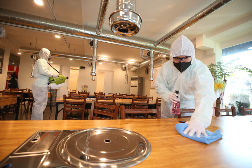 Disease prevention workers carry out sanitation and anti-bacterial and anti-virus coating at a restaurant in Daegu’s Suseong District on Tuesday. (Yonhap News)