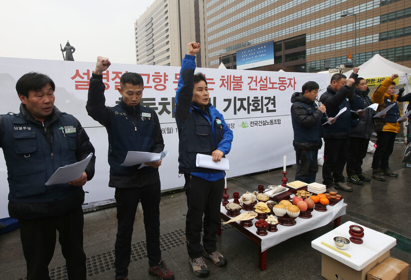 2015년 2월 전국건설노조 조합원들이 설을 앞두고 서울 광화문광장에서 합동차례를 지내고 나서 임금지급보증제도 등 법 개정을 통한 체불 임금 해결을 요구하며 구호를 외치고 있다. 연합뉴스.