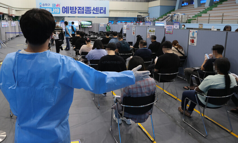 After receiving a vaccine, people sit in a waiting area in a COVID-19 vaccination center in Seoul as they monitor for adverse reactions Wednesday. (Yonhap News)