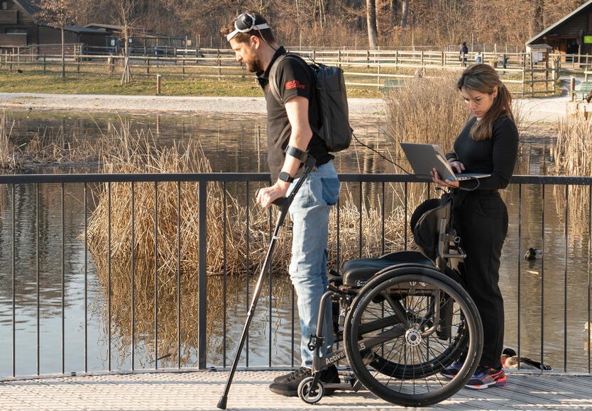 스위스 과학자들이 뇌와 척수 신경을 디지털로 연결하는 기술을 개발해, 하반신 마비 환자가 다시 걸을 수 있게 했다. 마비 환자가 야외에서 걷기 연습을 하고 있다. 스위스 로잔연방공대 제공