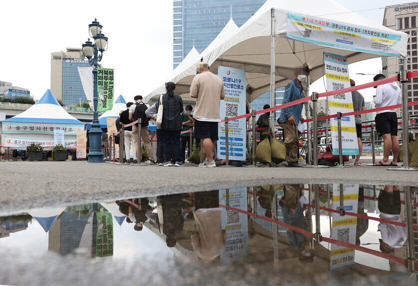 People wait in line at a temporary COVID-19 screening station in front of Seoul Station on Tuesday. (Yonhap News)