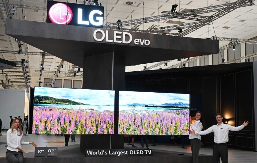People pose with TVs at LG Electronics’ booth at IFA 2022 in Berlin, Germany, in September 2022. (courtesy of LG Electronics)