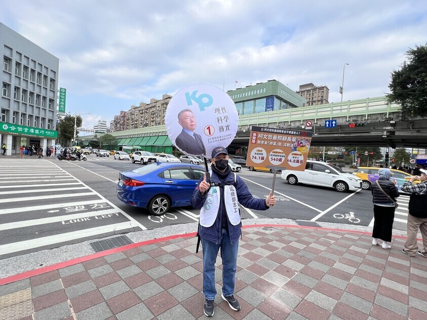 A campaigner for Ko Wen-je, the candidate for president for the Taiwan People’s Party, stands with signs outside a park in Taipei, Taiwan, on Jan. 7. (Lee Jeong-yeon/The Hankyoreh)