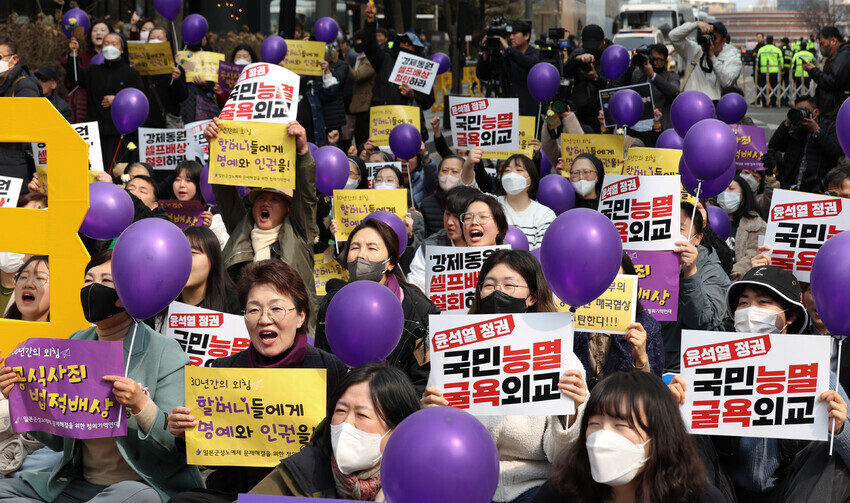 Participants in the March 8 Wednesday Demonstration, the 1,586th weekly rally on the issue of military sexual slavery by Japan, hold up signs condemning the Yoon Suk-yeol administration’s foreign policy as “degrading.” (Kim Jung-hyo/The Hankyoreh)
