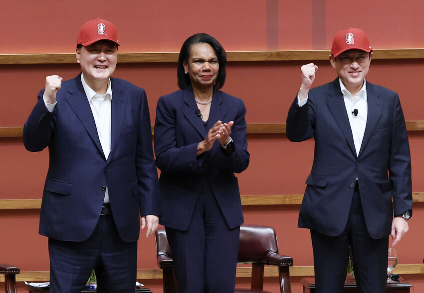 President Yoon Suk-yeol of South Korea (left) and Japanese Prime Minister Fumio Kishida don baseball caps gifted by Condoleezza Rice following their discussion at the Hoover Institution at Stanford University on Nov. 17 on the sidelines of the APEC conference in San Francisco. (Yonhap)