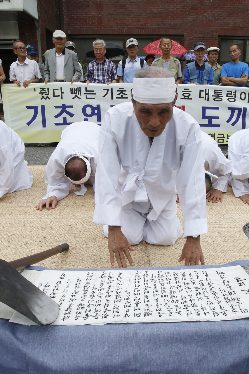 Elderly people recite an appeal for basic pension guarantee
