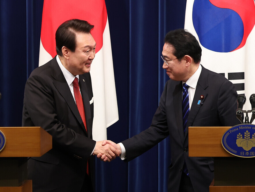 President Yoon Suk-yeol of Korea shakes hands with Prime Minister Fumio Kishida of Japan on March 16 following a joint press conference that took place after their summit that day. (Yonhap)