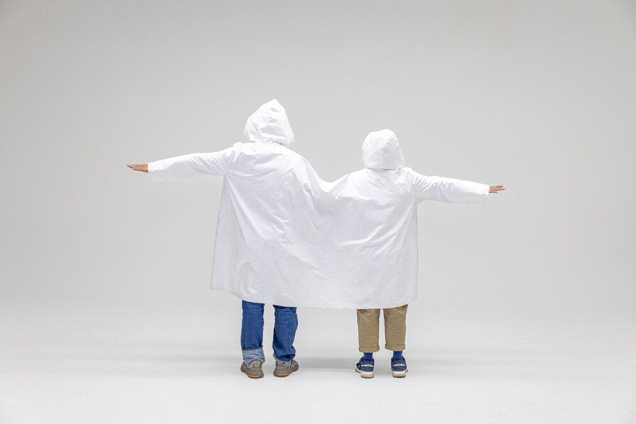 한 손으로 지팡이를 짚으면 우산을 쓸 수 없게 된 경험을 기반으로 송지은씨 부부가 ‘연결된 우비’를 입고 찍은 창작 사진. 라움콘, ‘1+1=1.5’, 2023.