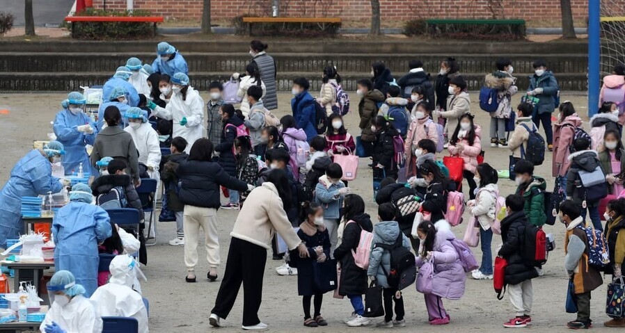 Elementary students in southern Gwangju’s Nam District wait to be tested for COVID-19 outside their school on Tuesday. (Yonhap News)