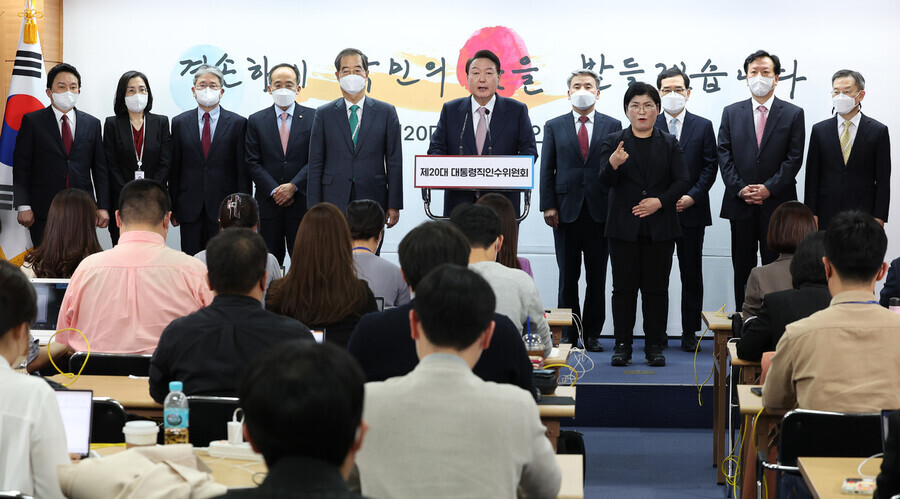 President-elect Yoon Seok-yeol stands with his picks to head eight of the country’s ministries on April 10 at the presidential transition committee’s offices in the Tongui neighborhood of Seoul. (pool photo)