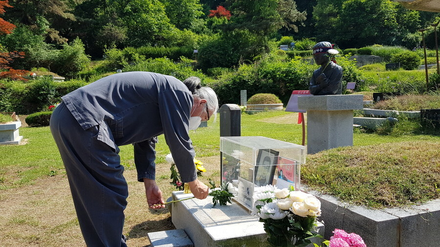 Kim Yong-hee, was unjustly dismissed from Samsung Aerospace in 1995, stands at the grave of late labor activist Jeon Tae-il on May 30, Kim’s just one day after ending his 355-day aerial protest on a tower in front of Samsung’s Seoul headquarters. (Kang Jae-gu)