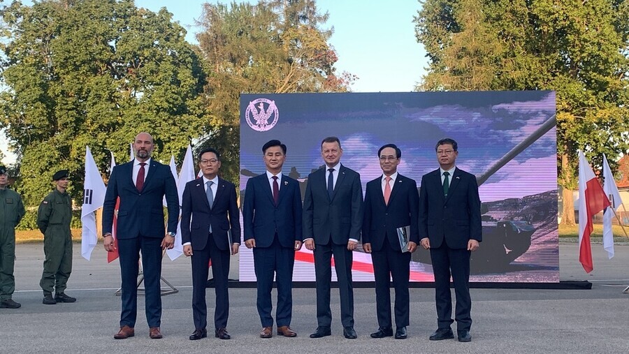 From left to right: Sebastian Chwalek, vice president of the Polish Armaments Group (PGZ) management board, Hanwha Defense CEO Son Jae-il, DAPA Minister Eom Dong-hwan, Defense Minister Mariusz Blaszczak of Poland, Hyundai Rotem President and CEO Lee Yong-bae, and Yu Dong-jun, the head of the South Korean Ministry of National Defense Office of Military Force and Resources Management, pose for a photo at the contract signing ceremony held in Poland on Aug. 26. (courtesy DAPA)