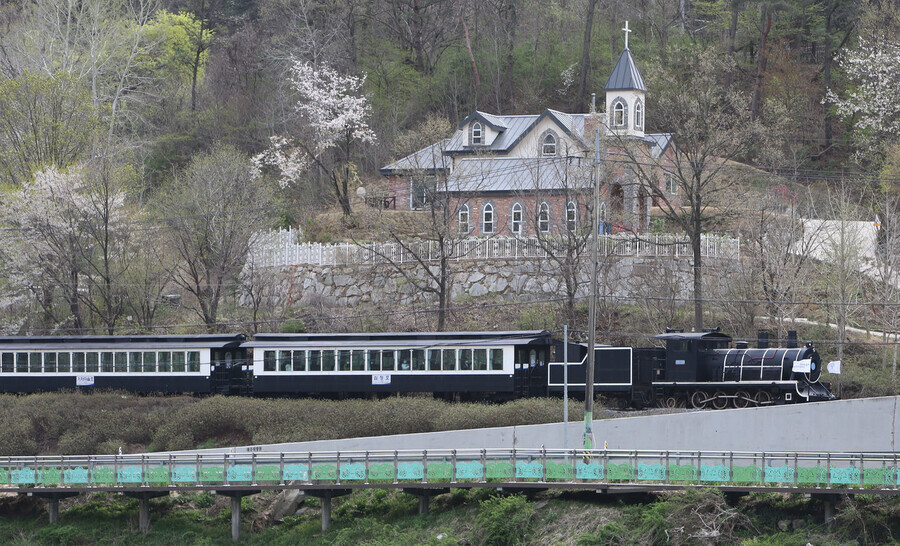 A train resembling a steam locomotive follows the cherry blossom trail down from Gokseong's 