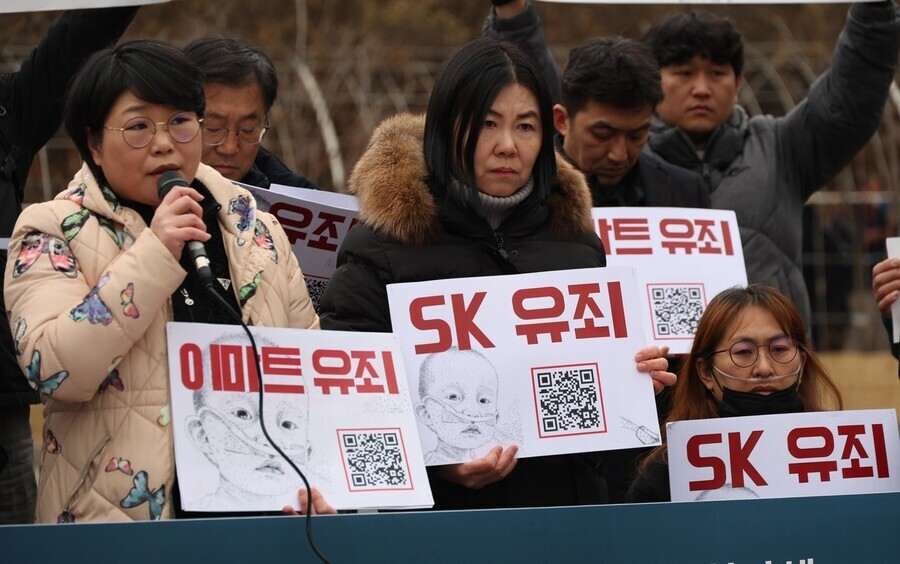 At a press conference held outside the Seoul Central District Court on Jan. 11, 2024, after the manufacturers of toxic humidifier disinfectants were found guilty of gross negligence, victims and their families read a statement while holding signs reading “Emart guilty,” and “SK guilty.” (Kang Chang-kwang/The Hankyoreh)