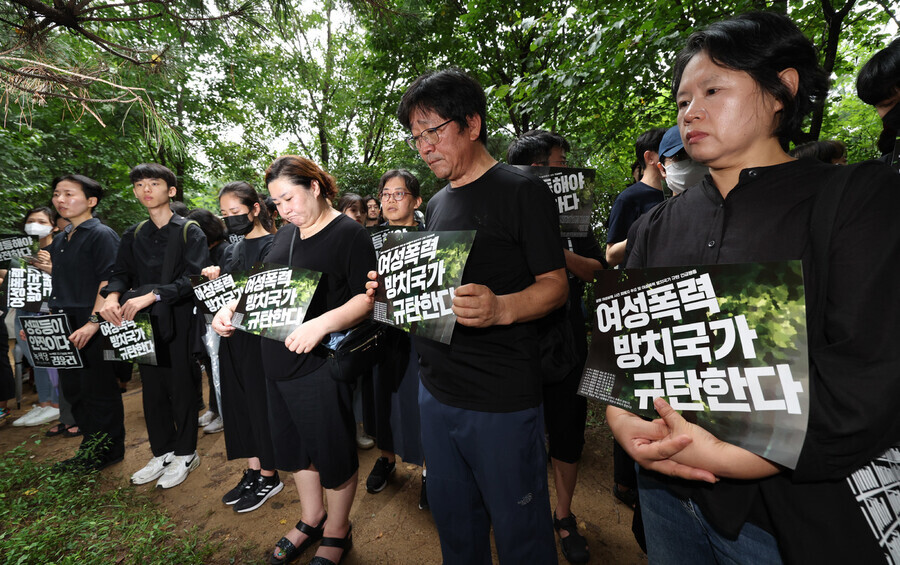 People gather on Aug. 24 at a park on Seoul’s Mt. Gwanak where a woman was killed by a man she did not know, where they hold signs condemning the state for doing nothing about violence against women. (Kim Jung-hyo/The Hankyoreh)