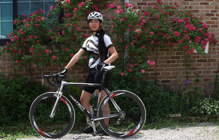Na Hwa-leen poses with her bike outside of a café in Gangwon Province’s Cheorwon County on May 31. (Baek So-ah/The Hankyoreh)