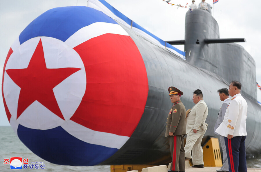 North Korea announced on Sept. 8 that it had launched a “tactical nuclear attack submarine.” Leader Kim Jong-un can be seen at the launch ceremony on Sept. 6 here with Kim Tok-hun, the North’s premier. (KCNA/Yonhap)