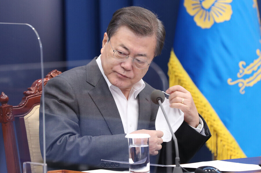 Moon takes his mask off to speak during a meeting with his senior secretaries Monday at the Blue House. (Yonhap News)
