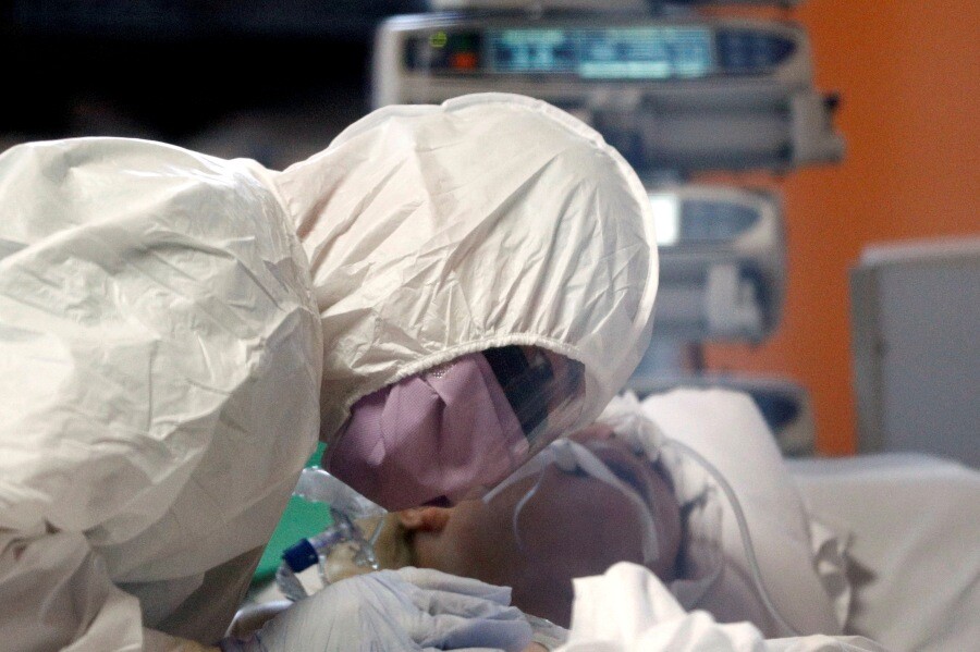 코로나19 치료기관으로 지정된 이탈리아 로마의 카살팔로코병원에서 3월24일 방호복을 입은 의료진이 코로나19 확진환자에게 몸을 한껏 기울여 진료하고 있다.