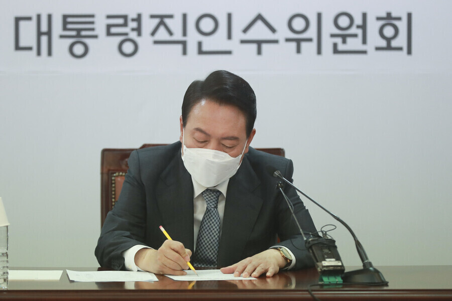President-elect Yoon Suk-yeol takes a memo during a meeting of the heads of his presidential transition committee’s subgroups at the committee’s offices in Seoul’s Tongui neighborhood on April 5. (pool photo)