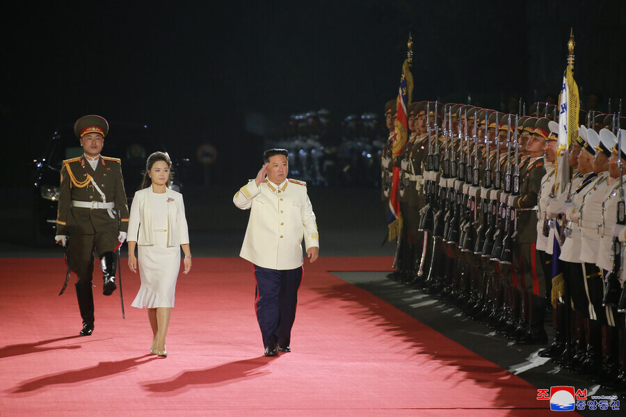 North Korean leader Kim Jong-un walks with his wife Ri Sol-ju to an event marking the 90th anniversary of the establishment of the Korean People’s Revolutionary Army, which was held at Kim Il-sung Square in Pyongyang on the evening of April 25, in this photo released by North Korean state media. (KCNA/Yonhap News)