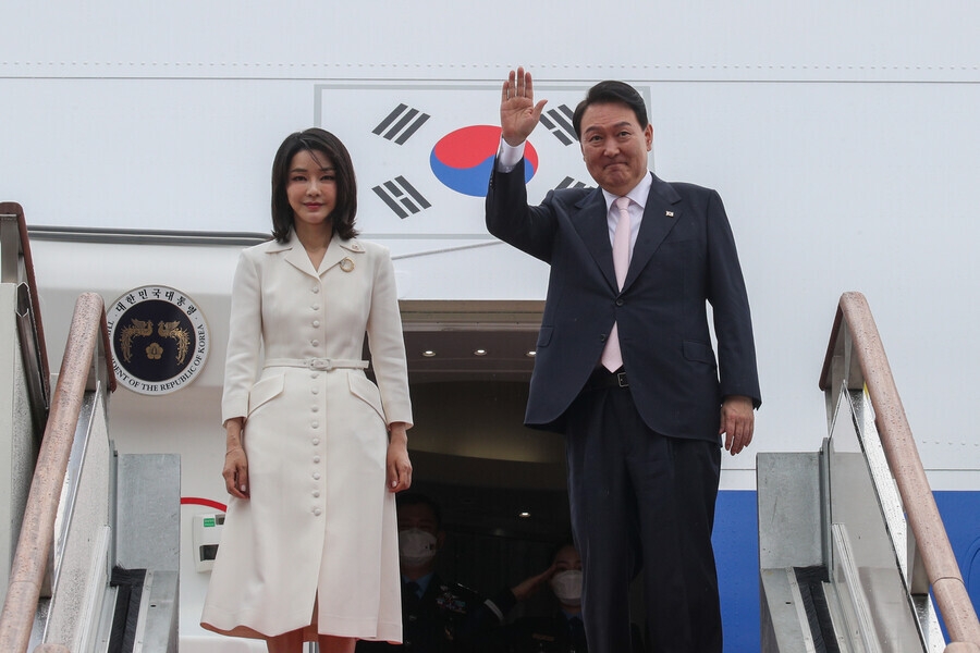 South Korean President Yoon Suk-yeol (right) and his wife, Kim Keon-hee, wave goodbye before boarding the presidential plane to depart on June 27 for the NATO summit in Spain. (presidential office pool photo)