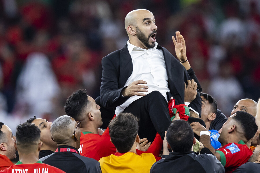 モロッコ代表チームのワリド・ラクラキ監督は、10日の準々決勝でポルトガルを破った後、選手のリンスを受ける. Doha/DPA Yonhap News