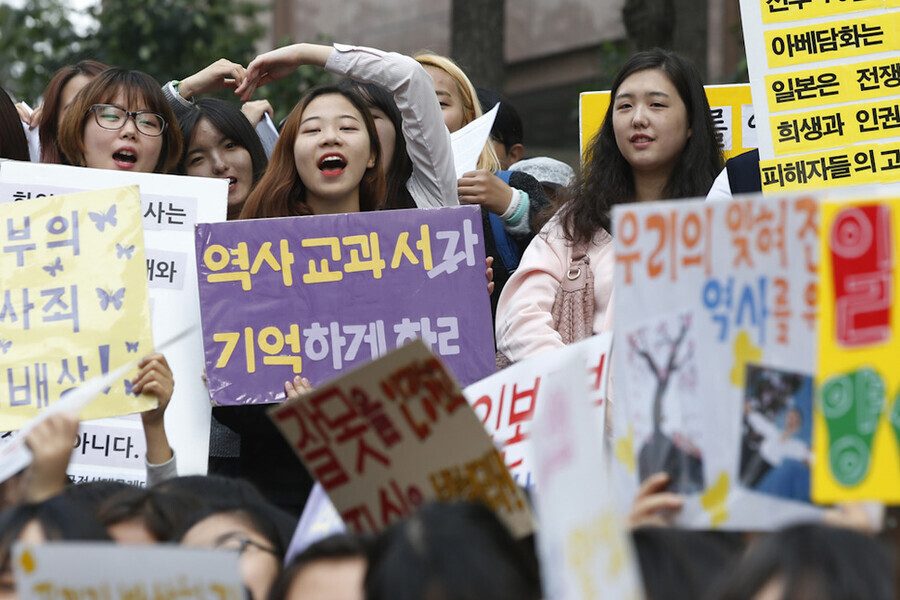 A participant in the 1,201st Wednesday Demonstration in Seoul in October 2015 holds up a sign reading “Make history textbooks remember!” (Lee Jeong-a/The Hankyoreh)