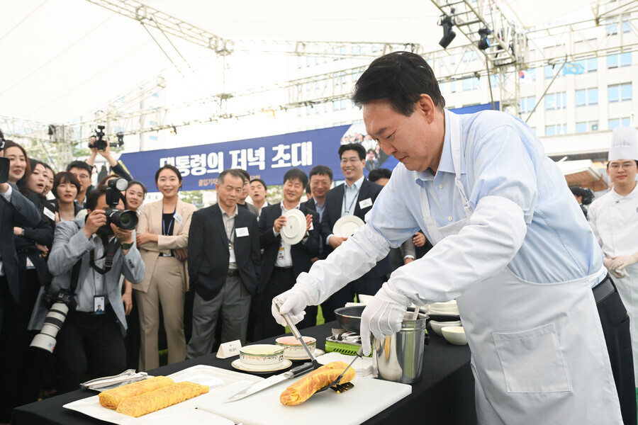 President Yoon Suk-yeol makes eggs at a luncheon for presidential office correspondents held on the office’s front lawn on May 24, 2024. (courtesy of the presidential office)