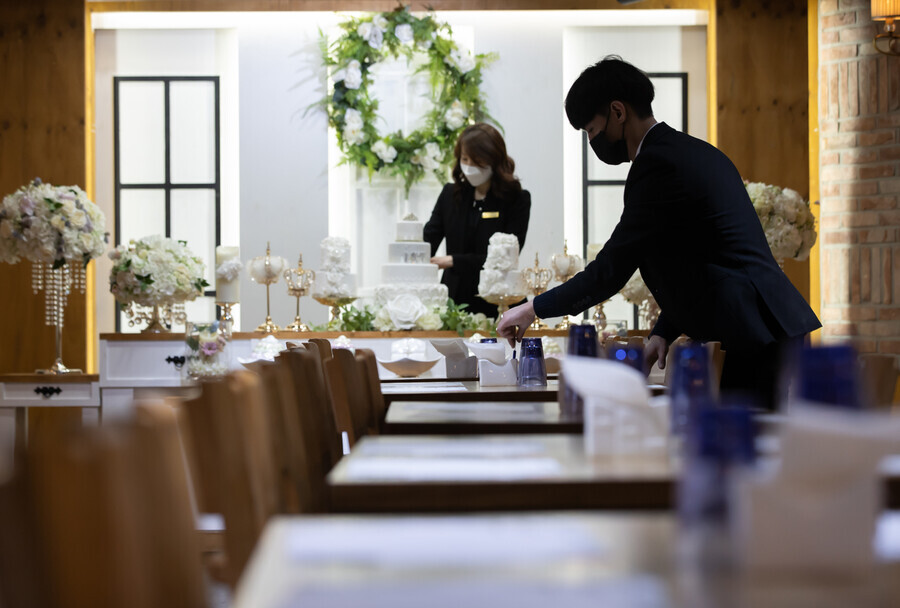 Employees of Elysian Party, an event venue in Seoul, organize tables on Sunday to reopen for business. (Yonhap News)