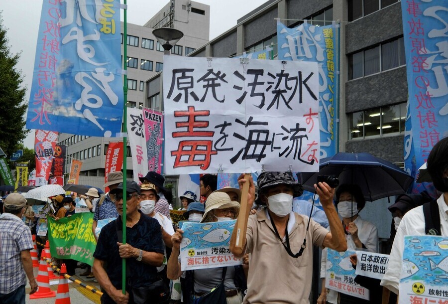 People carrying banners and signs with messages of opposition to Japan’s plan to release wastewater from the Fukushima nuclear plant into the ocean rally outside the prime minister’s office in Tokyo on Aug. 22. (AFP/Yonhap)
