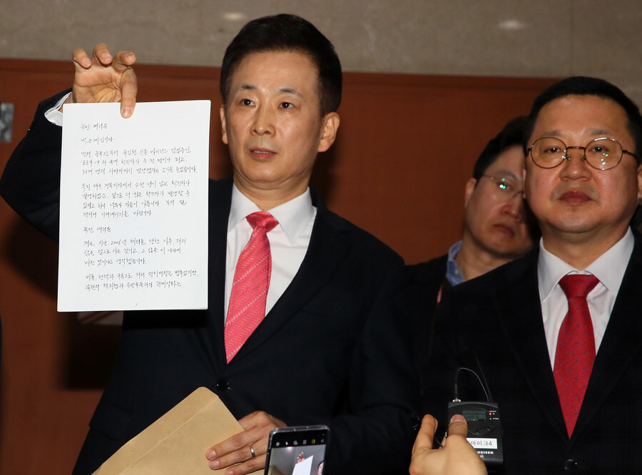 Yu Yeong-ha, attorney of former South Korean President Park Geun-hye, holds up a written message from Park calling on her far-right loyalists to join the mainstream conservative party on Mar. 4. (Yonhap News)