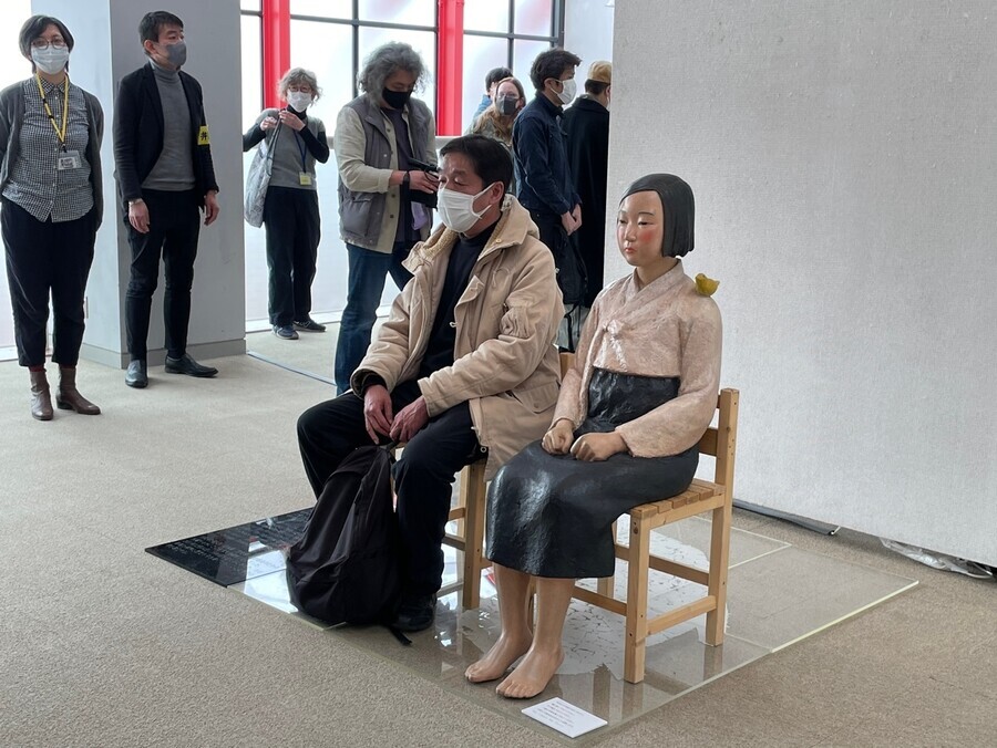 An exhibit-goer sits next to a Statue of Peace, a symbol of the victims of the Japanese military’s “comfort women” system of sexual slavery, at the “Non-Freedom of Expression Exhibition” at a public gallery in Kunitachi, Tokyo Prefecture, on April 2. (Kim So-youn/The Hankyoreh)