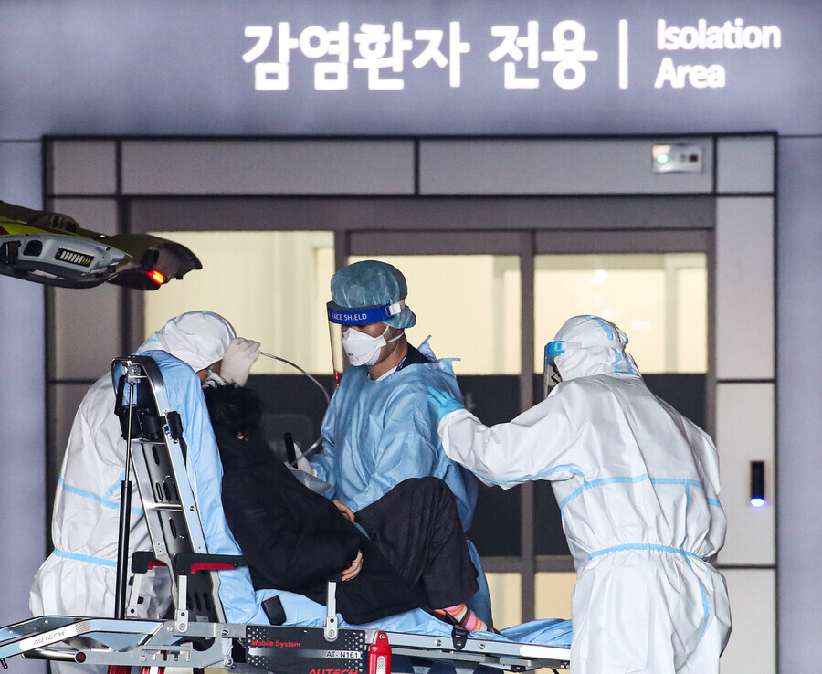 On Sunday, when a record-breaking number of serious or critically ill patients was recorded, medical workers transfer a patient from an ambulance to a dedicated COVID-19 hospital in Seoul’s Jungnang District. (Yonhap News)