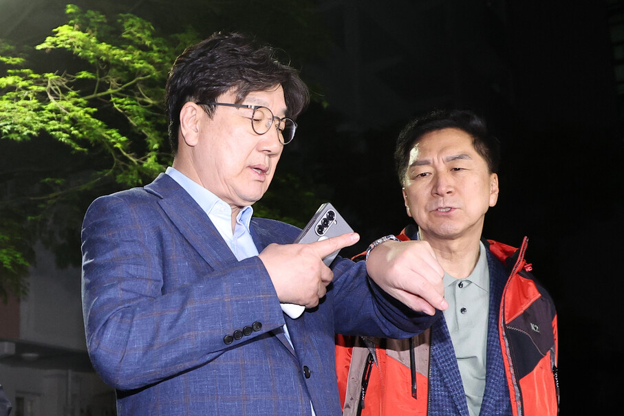 권성동 국민의힘 원내대표(왼쪽)가 2025년 5월6일 후보 단일화 압박에 반발하며 후보 일정을 중단하고 상경한 김문수 대선 후보를 만나기 위해 서울 관악구 김 후보의 자택 앞에서 기다리다 김 후보가 오지 않자 시간을 확인하고 있다. 연합뉴스