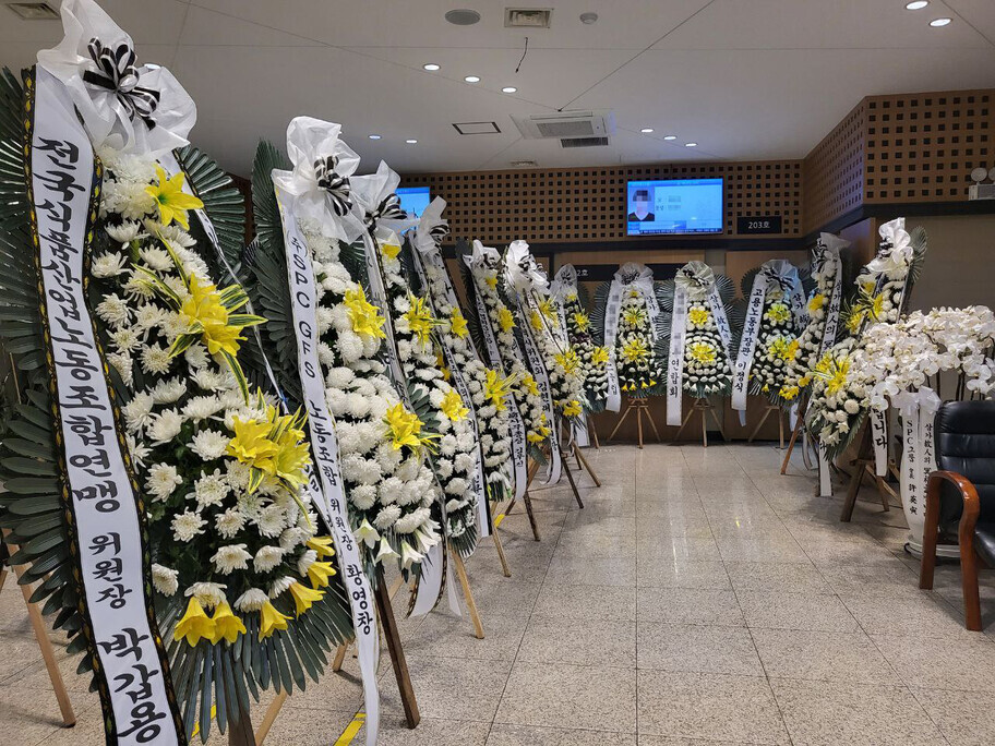 A worker at a baking factory operated by an SPC affiliate was killed after being caught in machinery. Numerous funeral wreaths sit outside the wake of the worker held on Oct. 17. (Jang Hyeon-eun/The Hankyoreh)