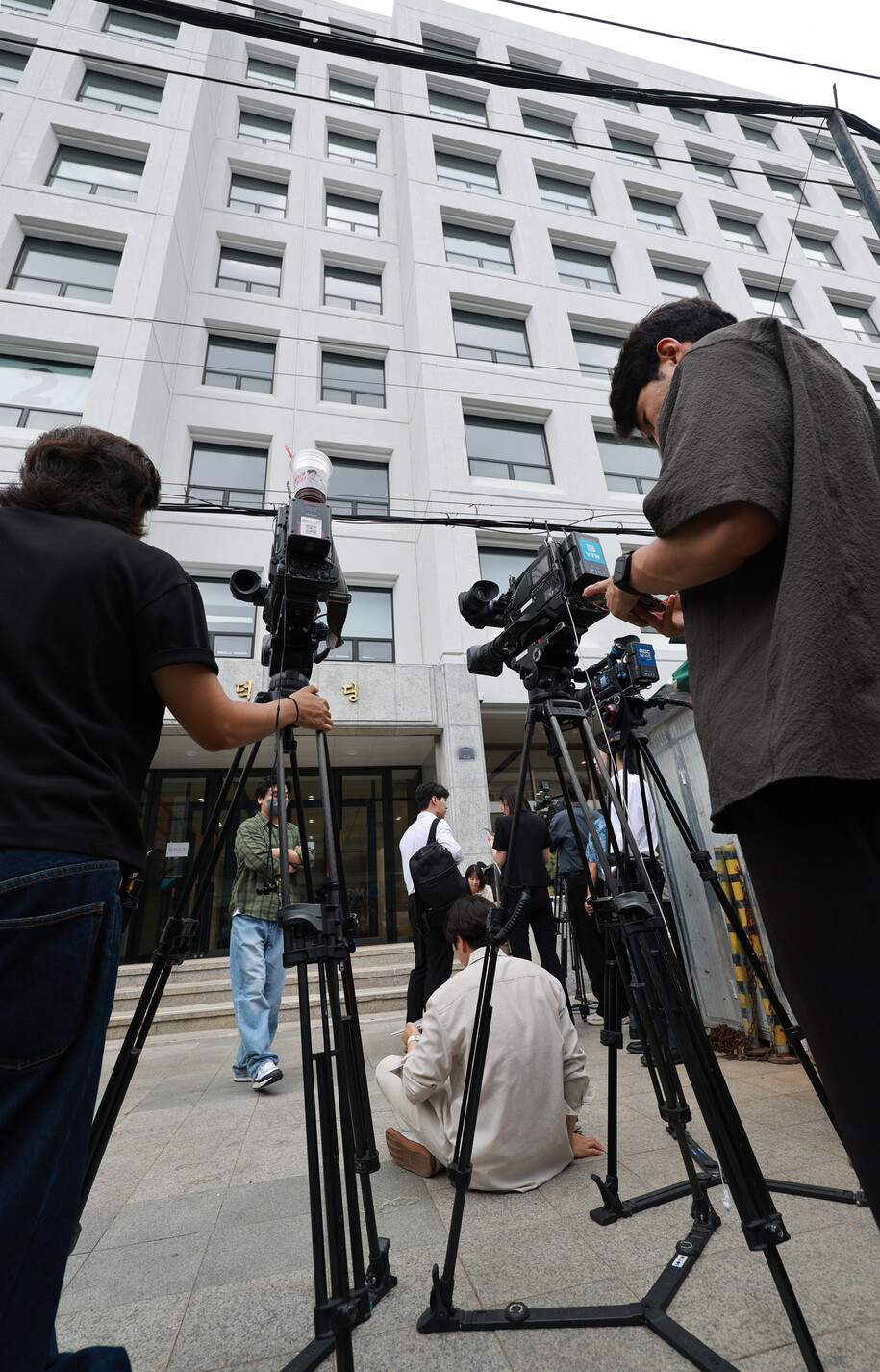 전 대통령 윤석열의 배우자 김건희씨를 둘러싼 의혹을 수사하는 민중기 특별검사팀이 2025년 7월3일 서울 종로구 삼부토건 본사를 압수수색하는 동안 취재진이 건물 앞에 모여 있다. 연합뉴스