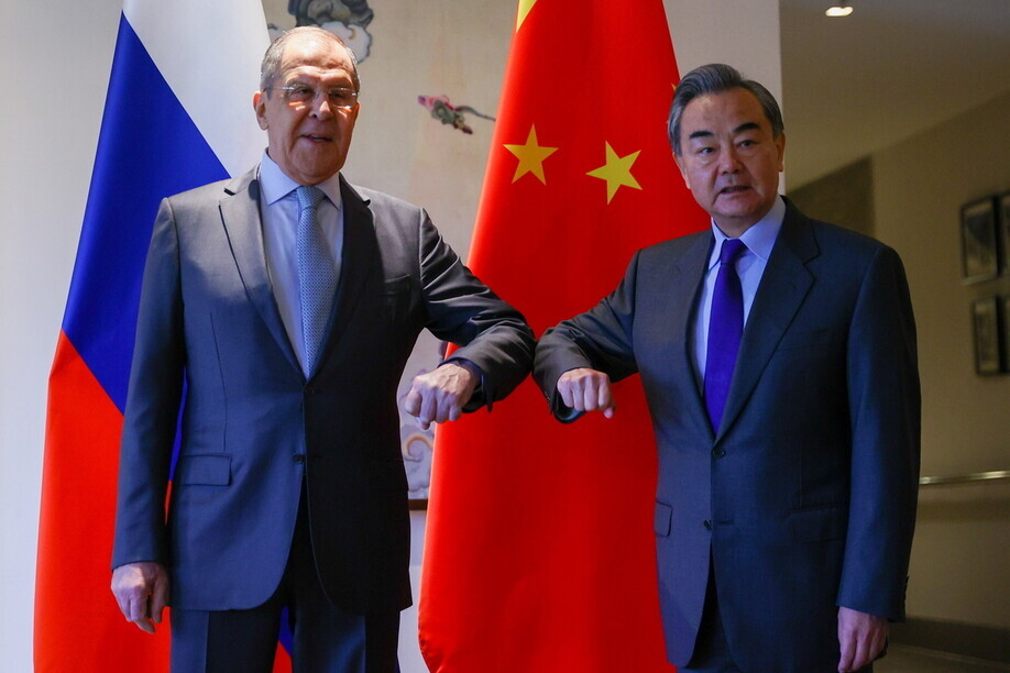 Russian Foreign Minister Sergey Lavrov bumps elbow with Chinese Foreign Minister Wang Yi during their meeting in Guilin, China on Tuesday. (EPA/Yonhap News)