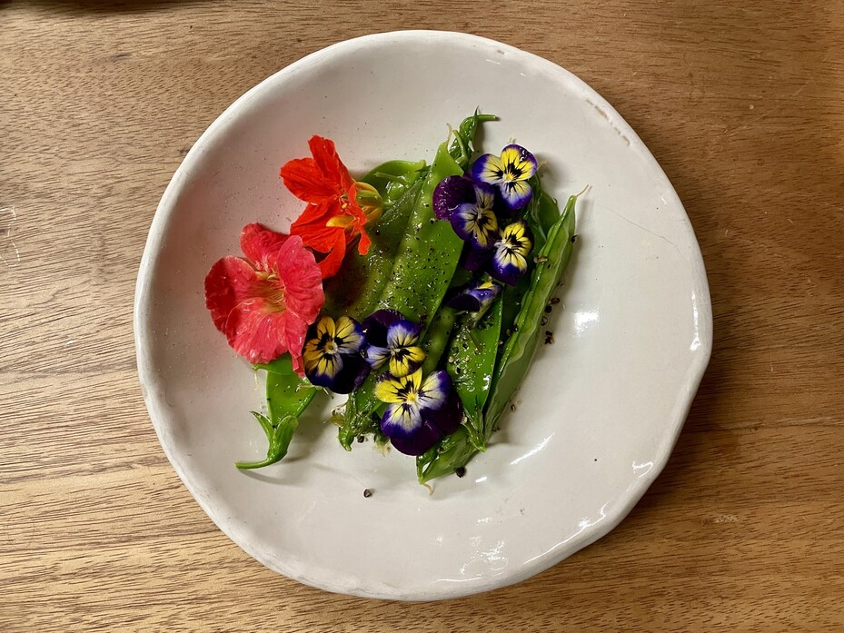 깍지도 먹을 수 있는 완두인 ‘스노피’를 기름에 볶아 꽃으로 장식해 접시에 담았다.