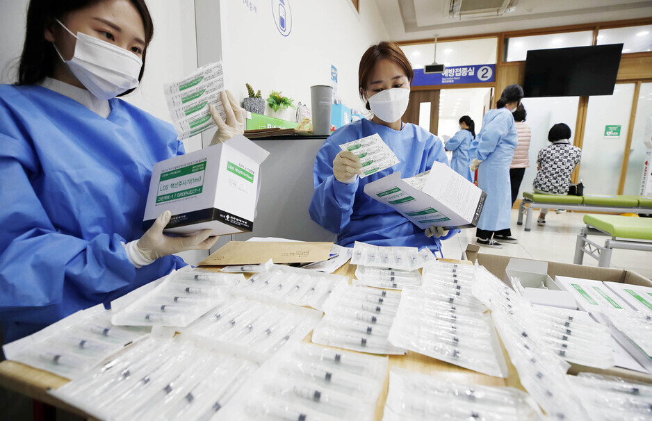 Health workers at a public health center in Gwangju inspect low dead space syringes that are to be distributed to vaccination centers across South Korea on Wednesday. (Yonhap News)