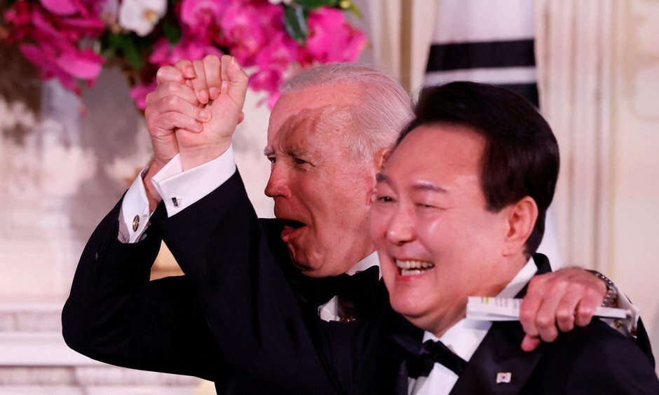President Joe Biden of the US holds up the hand of President Yoon Suk-yeol of South Korea at a state banquet held at the White House in Washington on April 26. (Reuters/Yonhap)