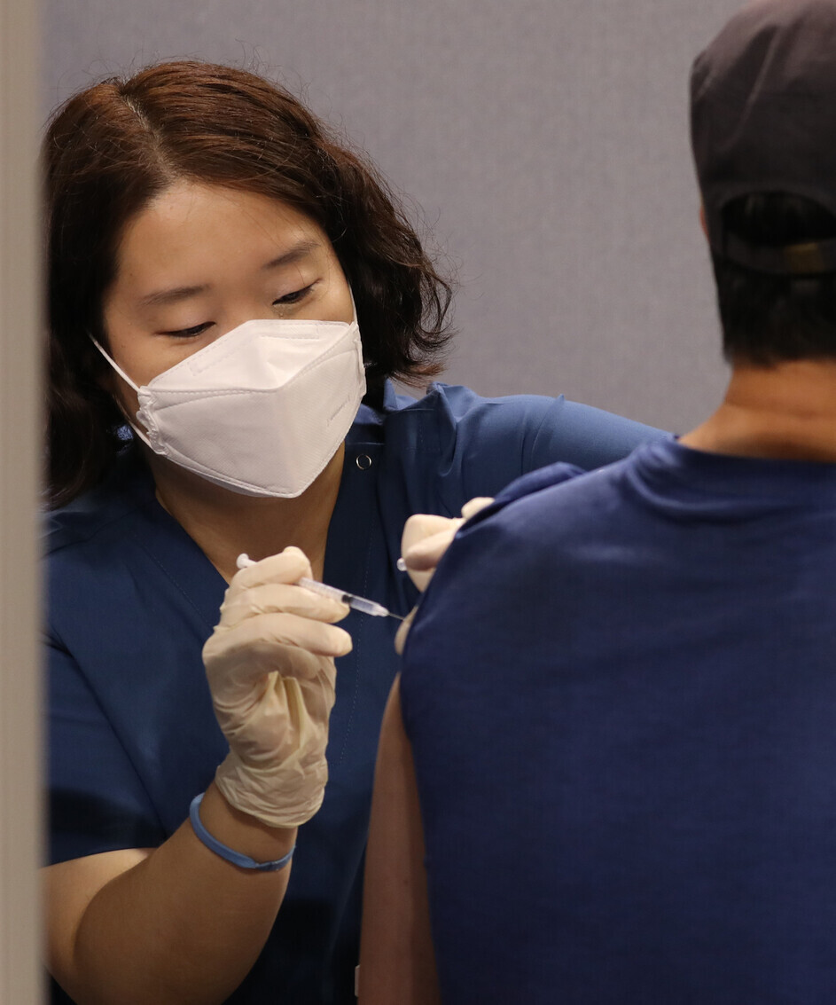 A health worker administers a COVID-19 vaccine to a man on Monday at a vaccination center in Seoul. (Yonhap News)
