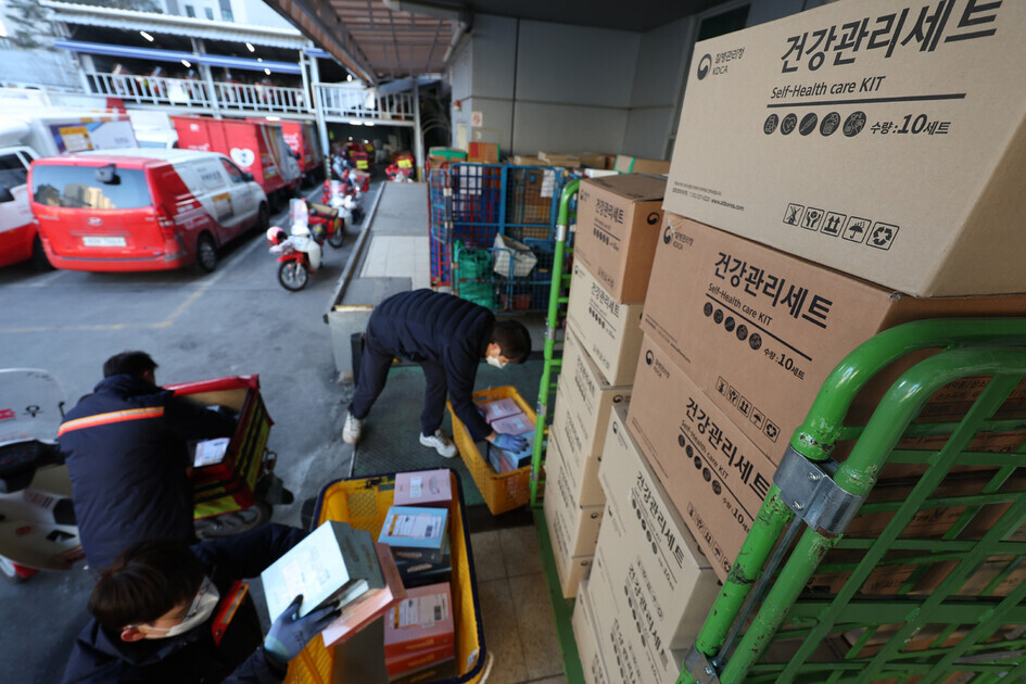 Workers at a post office in Seoul’s Dongjak District prepare COVID-19 at-home care kits to be sent out to patients undergoing at-home care on Tuesday. Currently, these kits include a fever reducer, a thermometer, a pulse oximeter, and sterilization supplies. Those belonging to high-risk groups are eligible to receive self-care kits. (Yonhap News)