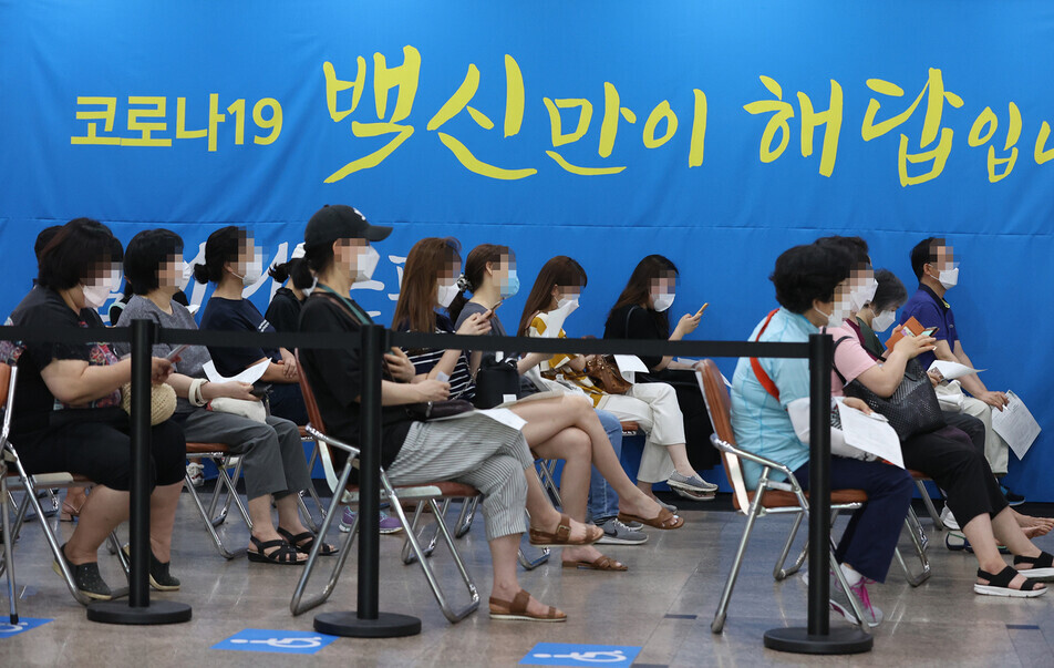People wait for their turn to get vaccinated at a vaccination center in Seoul on July 14. (Yonhap News)