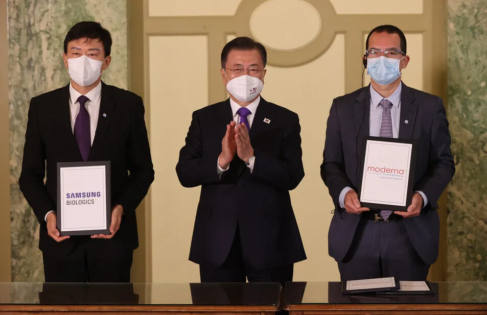 South Korean President Moon Jae-in poses for a picture with John Rim (left), CEO of Samsung Biologics, and Stephane Bancel, CEO of Moderna, at a hotel in Washington, on Saturday. (Yonhap News)